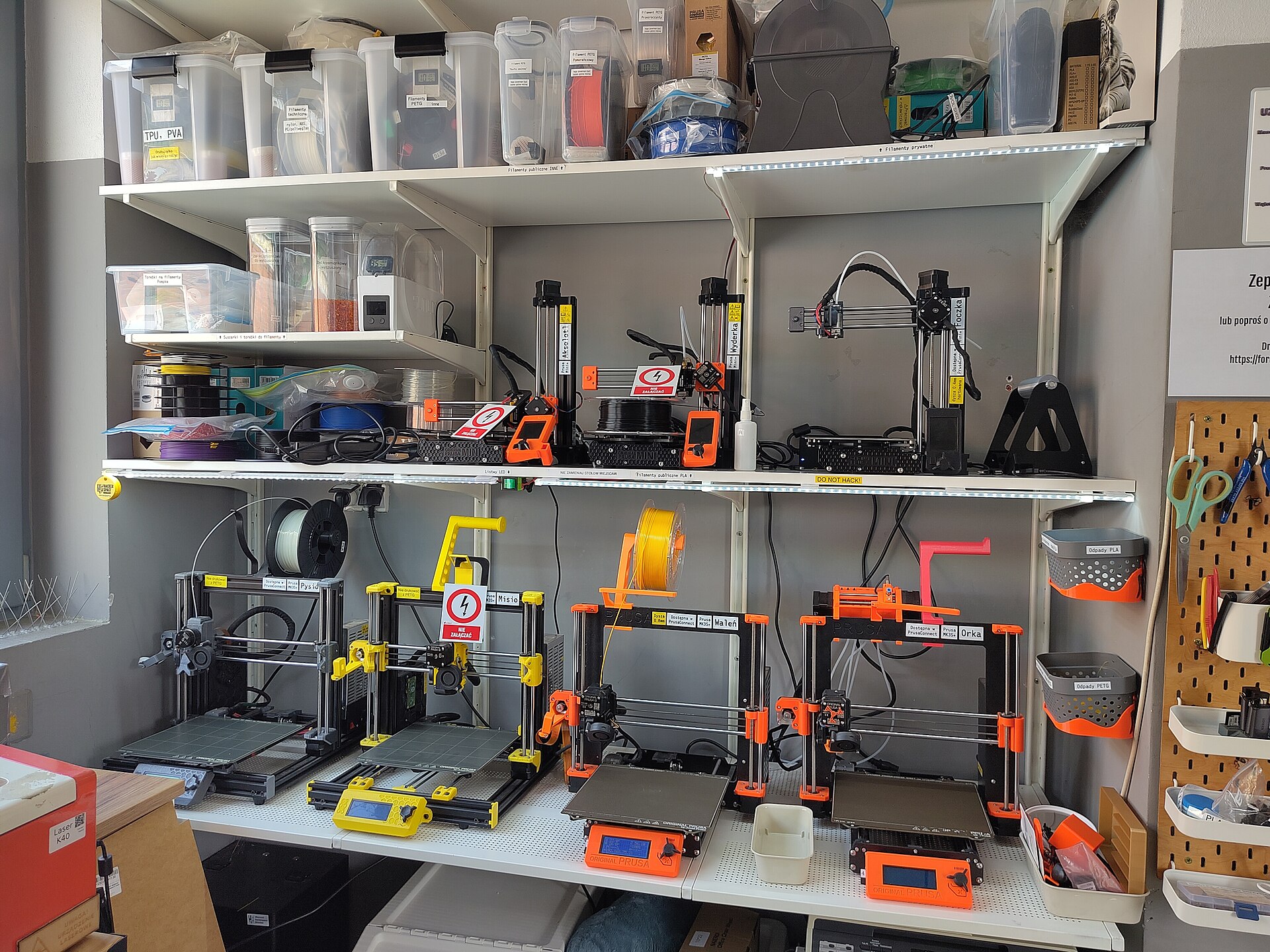 Several desktop printers lined up in a shared workshop