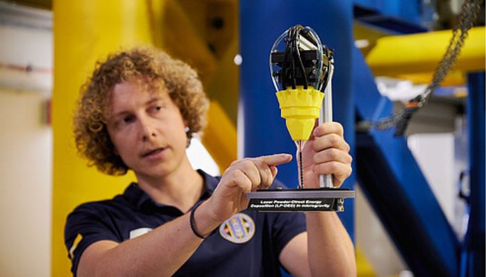 Marvin Raupert, project engineer, pictured with a model demonstrating the 3D printing process.