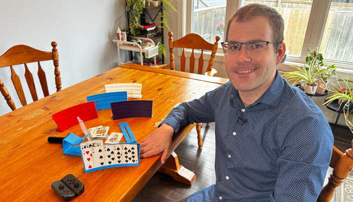 Nicolas Vaagen poses with some of the devices he created using a Bambu Lab 3D printer. (Photo Credit: CBC Canada)