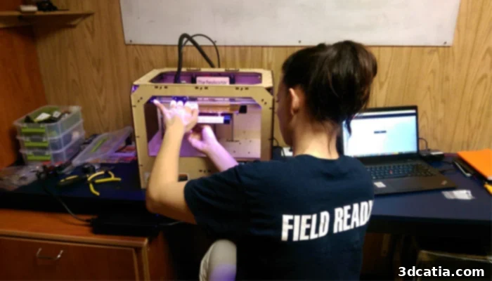 Field Ready team members collaborating in a workshop, utilizing 3D printing for humanitarian aid solutions.