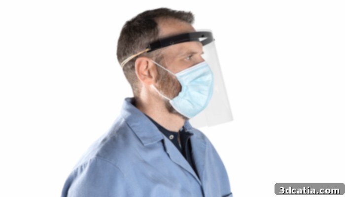 Technician wearing a 3D printed face shield, highlighting the practical applications of additive manufacturing during the COVID-19 crisis.