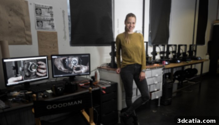 Dora Goodman proudly stands next to her Anycubic i3 Mega 3D printers in her bustling workshop, showcasing the tools of her craft.
