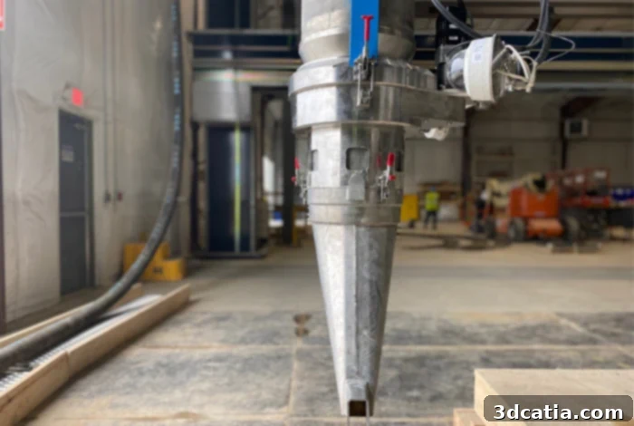 Nozzle of a concrete 3D printer laying down layers of concrete for a wind turbine base.