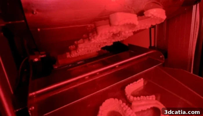 Sprybuild's resin 3D printer with a conveyor belt for continuous, automated production.