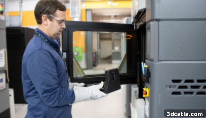 GM AM technical specialist Paul Wolcott removes a finished part from a 3D printer at the Warren Technical Center campus